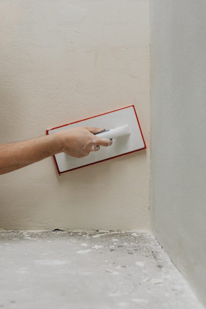 Hand smoothing drywall joint with a drywall knife.