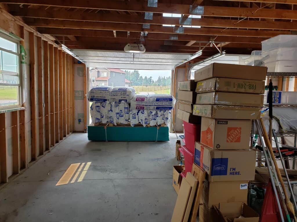 Warehouse interior with stacked boxes and pallets under wooden beams.